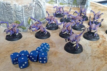 StarCraft TMG - Zergling-Miniaturen aus dem StarCraft Tabletop Miniatures Game im Größenvergleich, die die massive Skalierung der Modelle zeigen (Quelle: Goonhammer)
