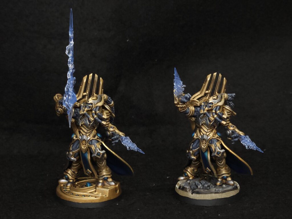 StarCraft TMG - zwei bemalte Protoss-Miniaturen in Gold und Blau mit transparenten Psi-Klingen, Community-Malarbeit (Quelle: https://www.reddit.com/r/StarCraftTMG/comments/1wmru1f/grinding_away_on_a_protoss_army/)