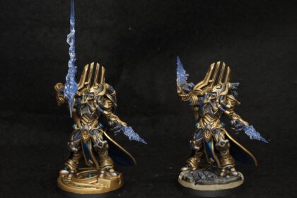 StarCraft TMG - zwei bemalte Protoss-Miniaturen in Gold und Blau mit transparenten Psi-Klingen, Community-Malarbeit (Quelle: https://www.reddit.com/r/StarCraftTMG/comments/1wmru1f/grinding_away_on_a_protoss_army/)
