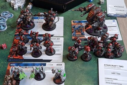 StarCraft TMG - bemaltes 1000-Mineralien-Terran-Heer mit Einheitenkarten und offiziellem Roster-Sheet auf dem Spieltisch, fotografiert von Reddit-Nutzer eli_cas (Quelle: https://www.reddit.com/r/StarCraftTMG/comments/1wnhggy/6th_game_tonight_1k_minerals_5th_loss_but_at/)